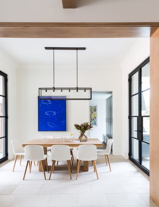 Dining room with bold blue artwork and pendant lighting