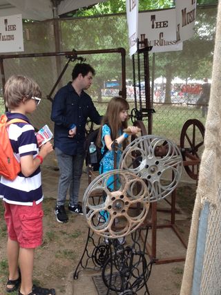 Maker Faire attendees try out an interactive percussive instrument made out of recycled materials.