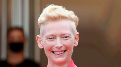 British actress Tilda Swinton (L) and Us actor Adrien Brody smile as they arrive for the screening of the film "The French Dispatch" at the 74th edition of the Cannes Film Festival in Cannes, southern France, on July 12, 2021. (Photo by Valery HACHE / AFP) (Photo by VALERY HACHE/AFP via Getty Images)