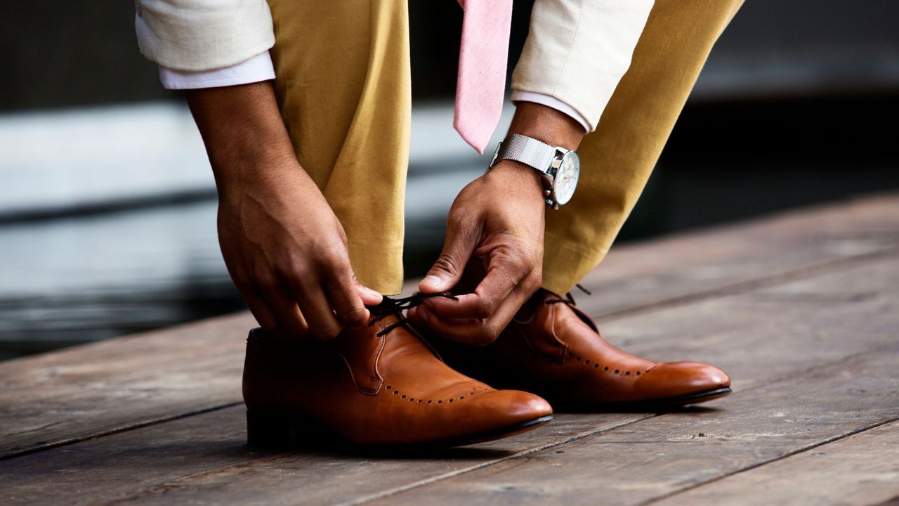 Male escort: A man tying his shoe laces