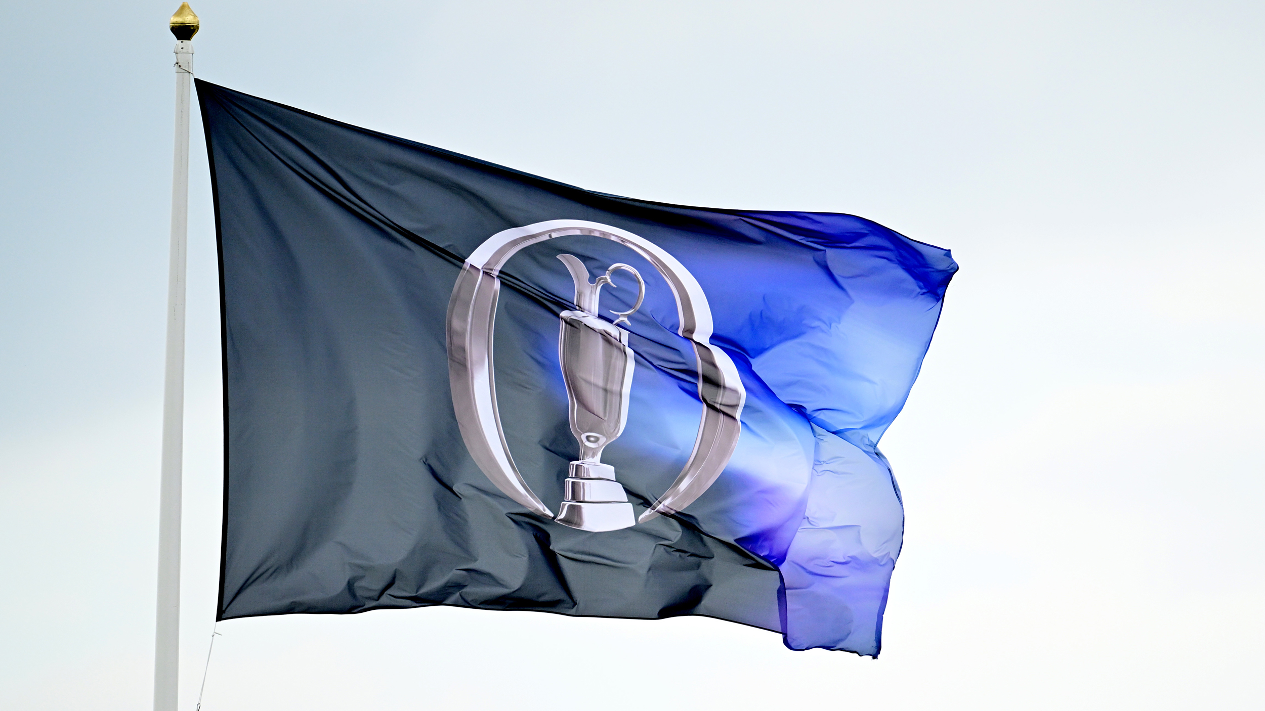 A blue Open Championship flag flying in the wind
