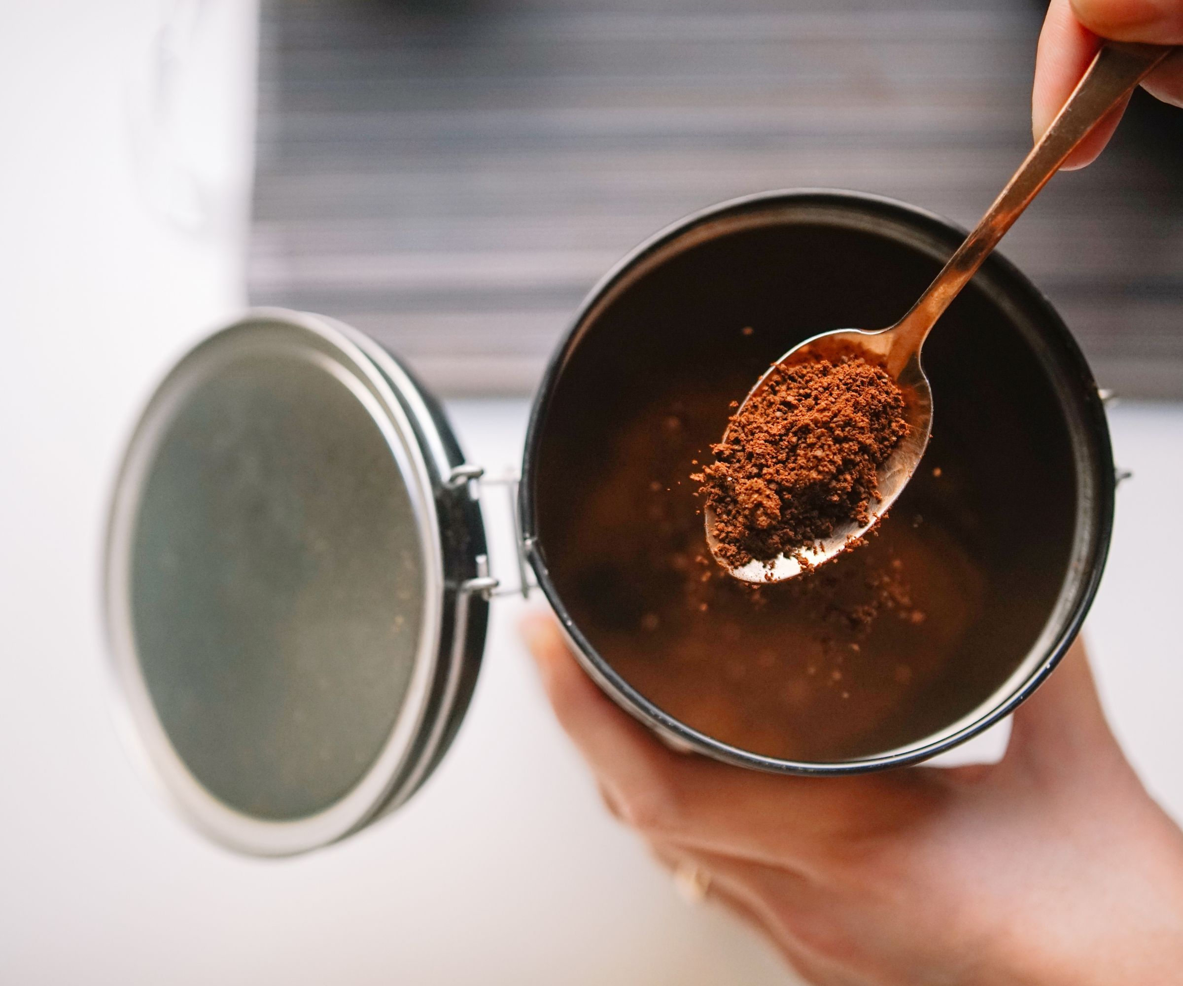 instant coffee being scooped out of a cannister