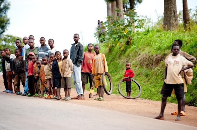 Local children cheer up riders with old bicycle tire