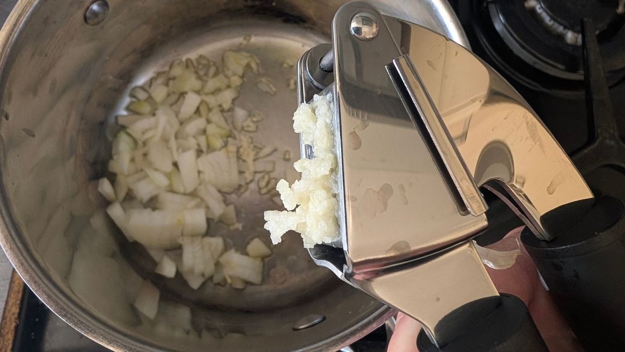 Crushing garlic using one of the items from the Salter Expert 4-piece Kitchen Utensil Set during testing