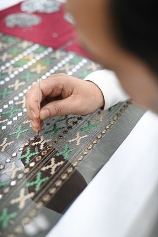 A person stitching embroidery