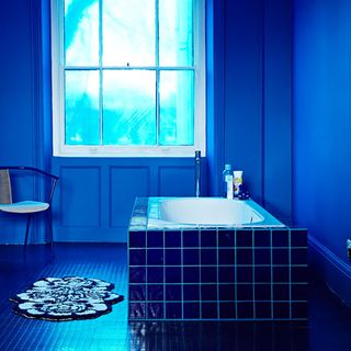 bathroom with navy blue title flooring and bathtub