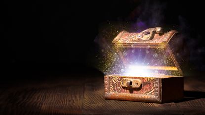Treasure box half opened in a dimly lit room with magic lights coming out of the box