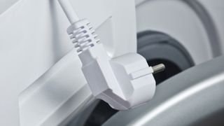 Fragment of a washing machine close-up with electric plug