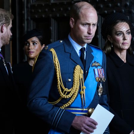 Prince William and Princess Kate standing in front of Prince Harry and Meghan Markle at Queen Elizabeth's funeral