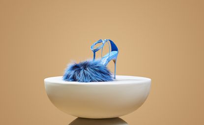 Blue sandal on white curved podium, shoe by Kendall Miles