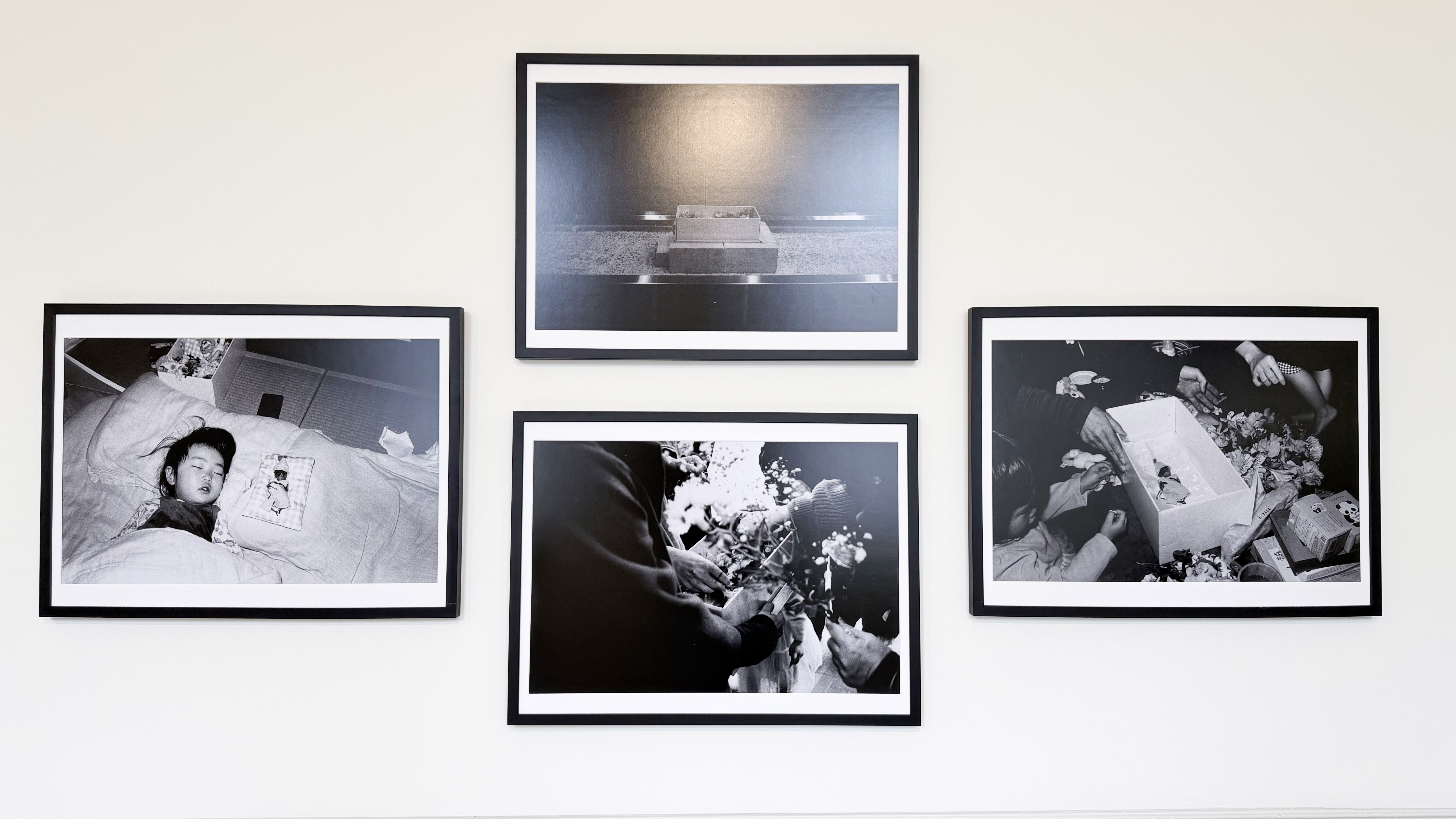 A photo of four images in black and white hosted on an exhibition wall.