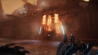 Doom: The Dark Ages fire door - A first-person image of Doom Guy looking at a door blocked by fire, holding a gun and shield at the ready.