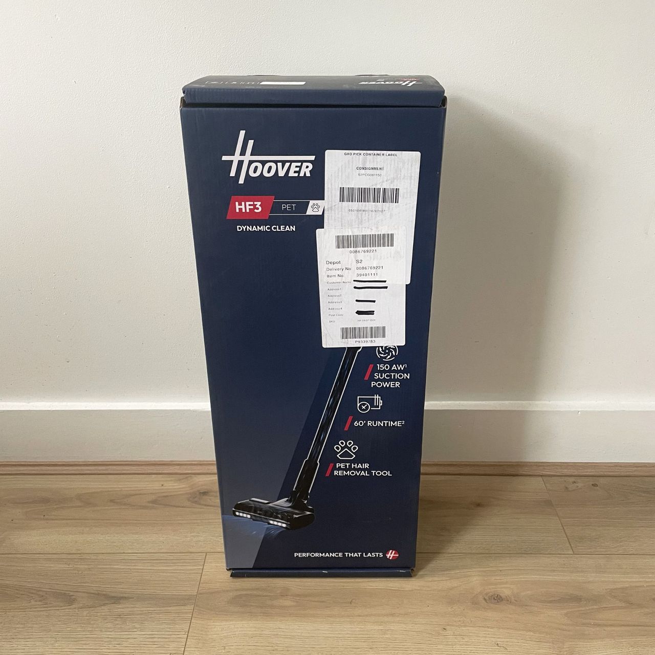 Hoover HF3 box sitting on wood-effect flooring in front of a white wall