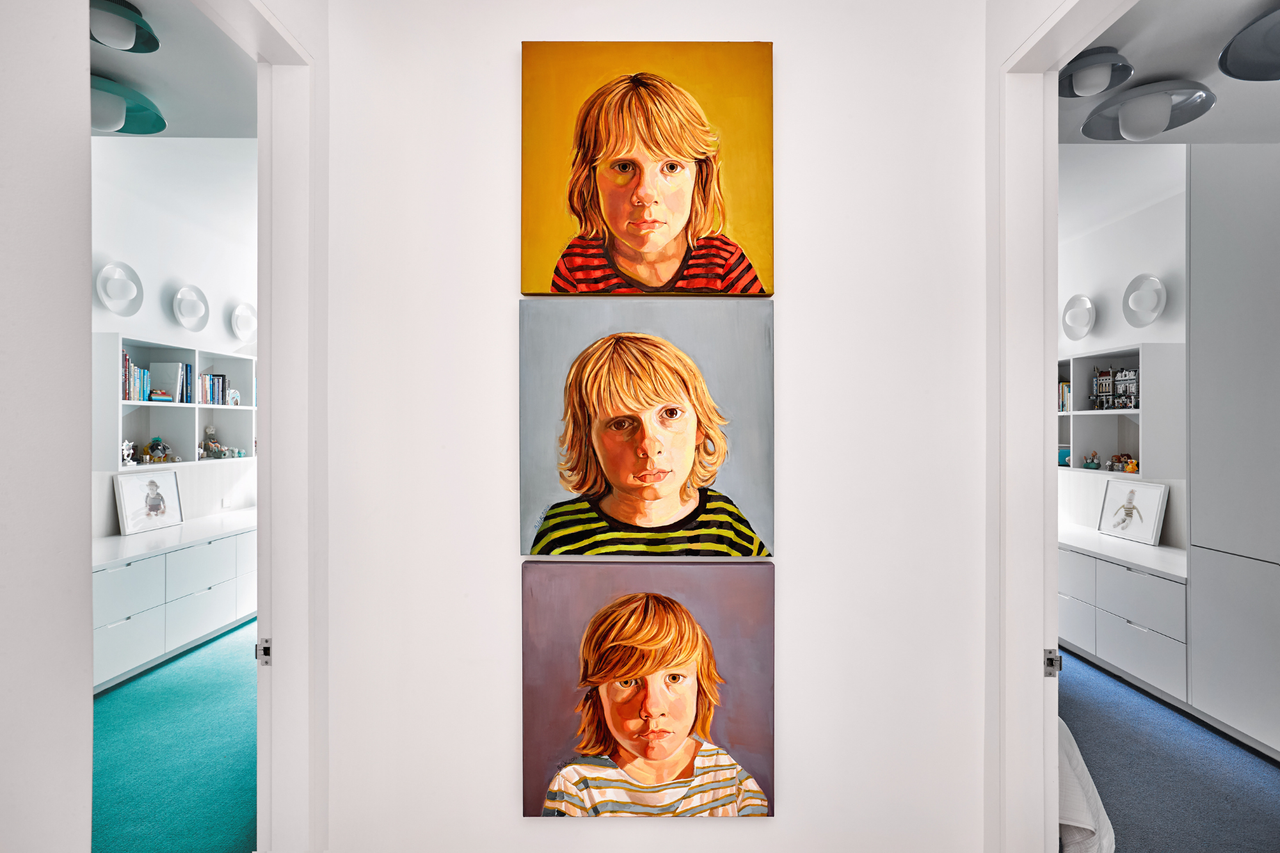a white wall between two rooms with three images of children in bright pop art style