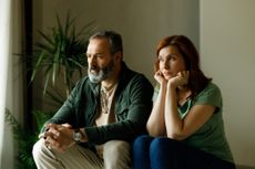 Mature couple fighting at home sitting on the sofa.