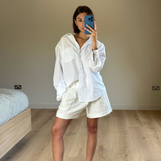 woman wearing oversized white button-down shirt and white loose shorts summer 2025