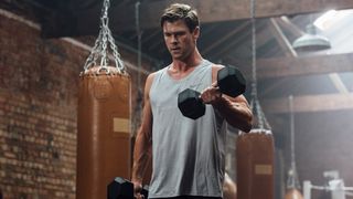 Chris Hemsworth doing dumbbell curl in gym
