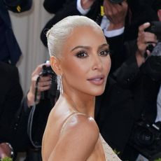 Kim Kardashian wears Marilyn Monroe's sparkly nude dress to the Met Gala, and has bleached blonde hair and diamond drop earrings, and she shows off her new Tesla robot on social media