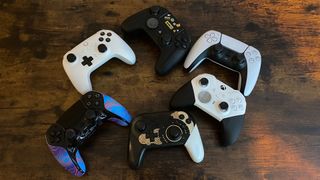 Six video game controllers on a coffee table.