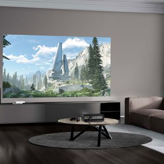 a projector in a living room with a grey sofa