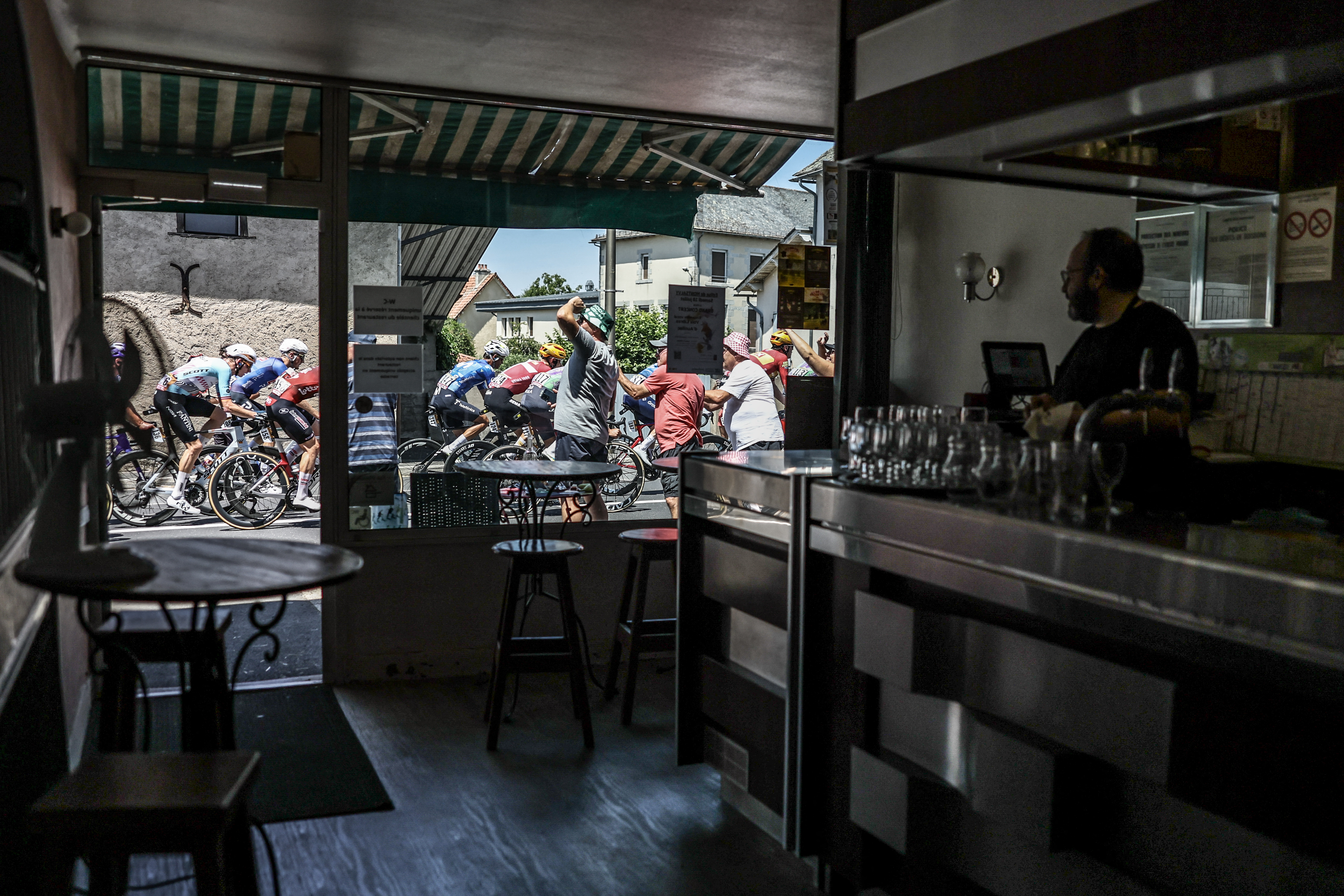 The Tour de France peloton passes a bar