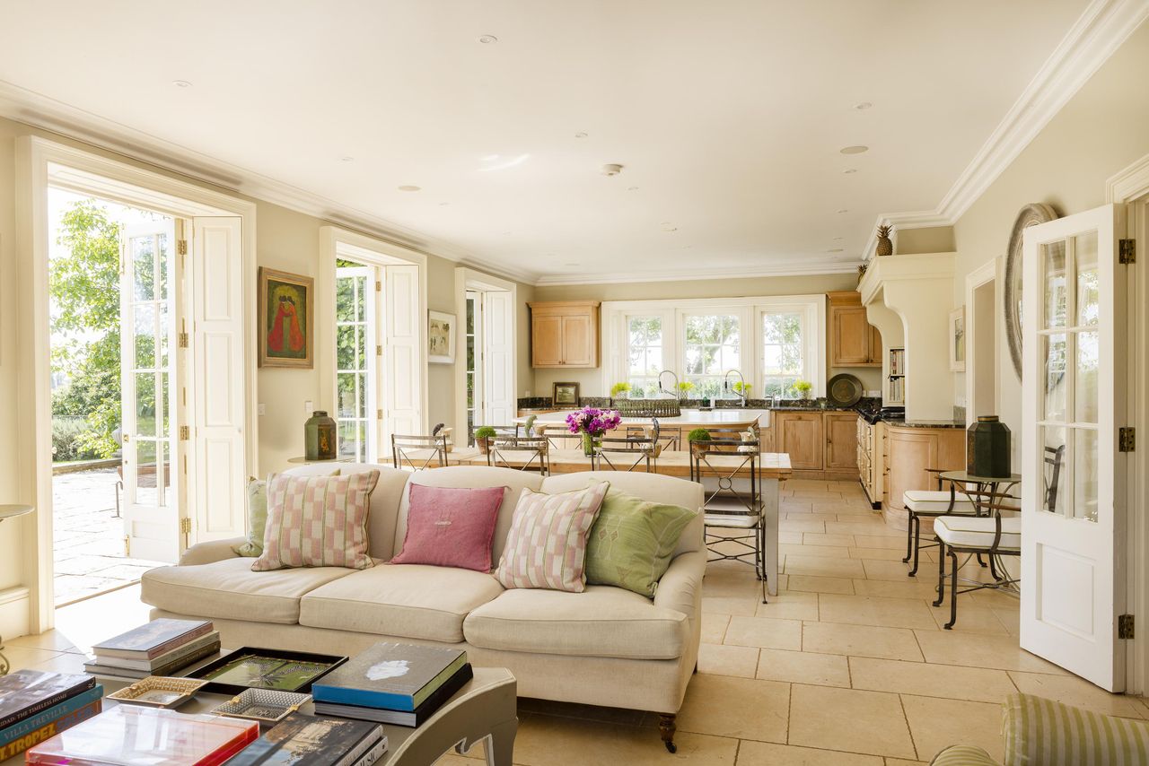 Mount Farm's living room with beige sofa with colourful pillows and plenty of light streaming in