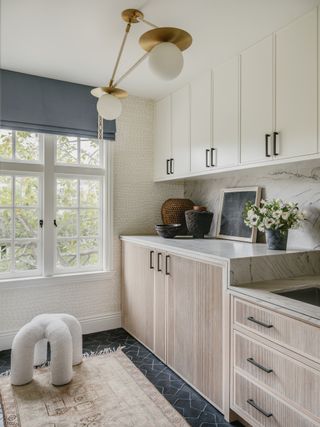 laundry room wooden cabinetry, grey floor tiles, grey blind, opal pendant, textured wall, countertops, rug