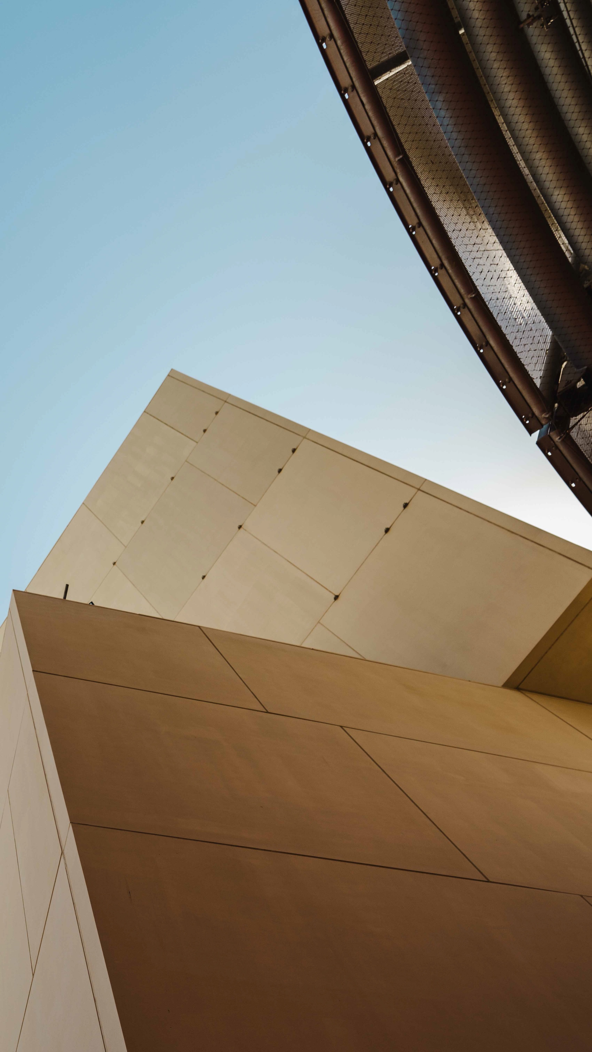 Guggenheim Abu Dhabi exterior images featuring a geometric assemblage of volumes made from steel glass timber and stone