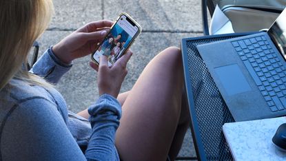 A woman looks at her smartphone