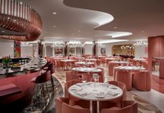 The rose-hued, velvety interiors of a restaurant convey a retro-futuristic feel.