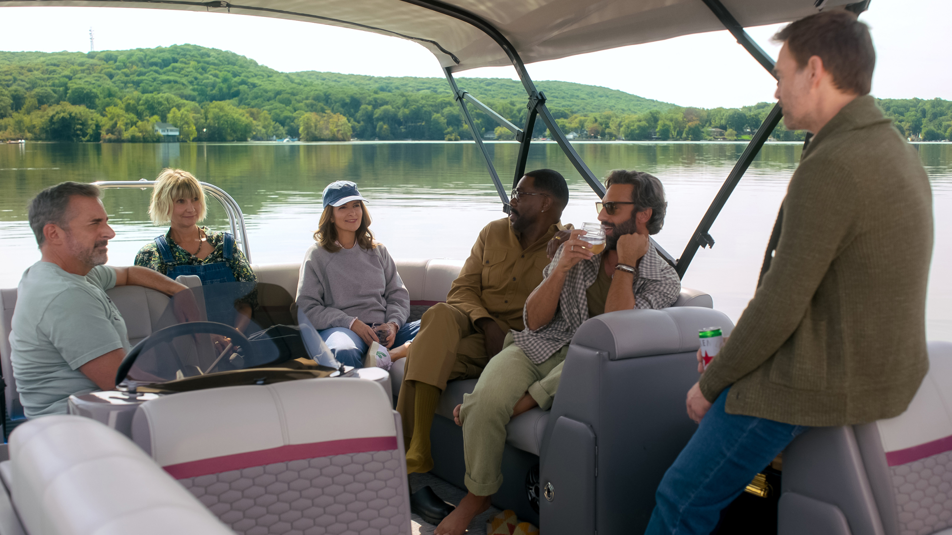 A group of people (l-r: Steve Carell as Nick, Kerri Kenney as Anne, Tina Fey as Kate, Colman Domingo as Danny, Marco Calvani as Claude, and Will Forte as Jack) sit on a boat in the middle of a lake, in Episode 101 of The Four Seasons.