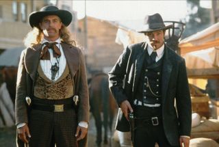 a still from deadwood of two cowboys drawing their guns