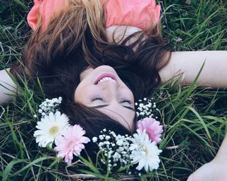 girl with flower crown laying on lawn