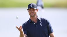 Hudson Swafford smiles while catching a golf ball during LIV Golf UK in 2024