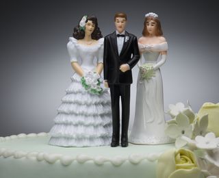 A plastic cake topper includes one groom and two brides.