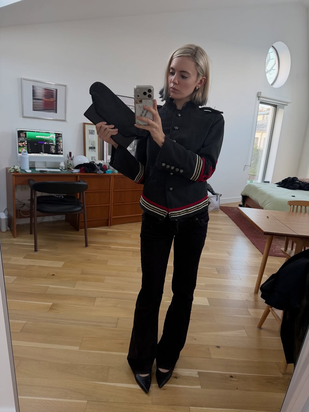 @susiegarvie wears black bootcut jeans, heels, and a coat.