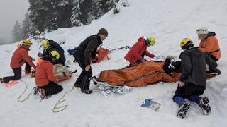 North Shore Rescue load up a hiker in a Sked after they broke their ankle bum sliding