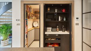 view of pantry style cupboard with open doors in kitchen leading to room next to it that functions as a pantry