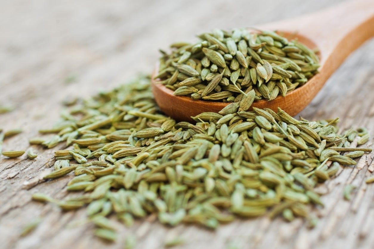 Pile Next To Wooden Spoon Full Of Anise Seeds