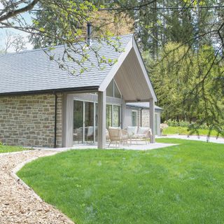 Green grass lawn with wood chip path and bungalow