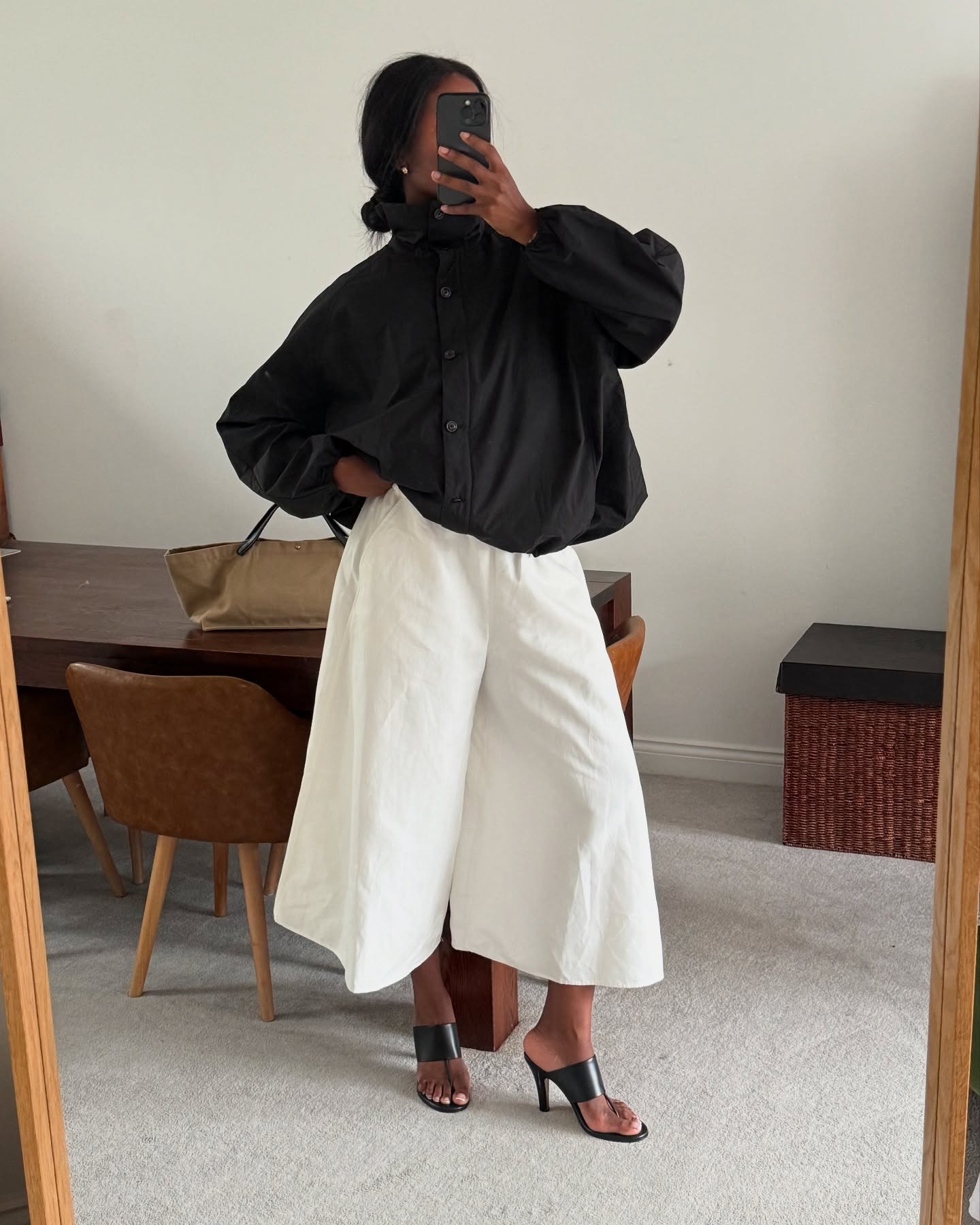 Influencer wearing chic, minimalist black and white outfit.