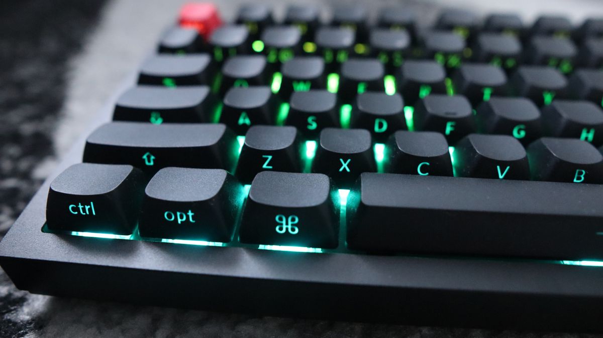 The Keychron Q3 Max gaming keyboard set-up on a desk with the RGB lighting enabled.