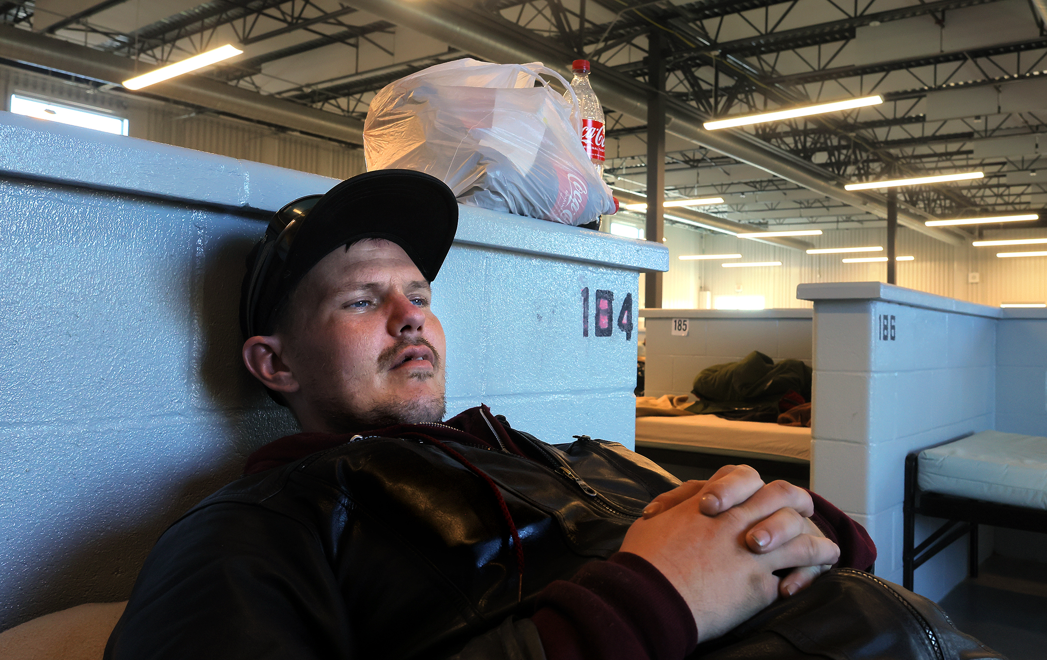 A homeless Army veteran with PTSD rests in his bed at the Homeless Services Center