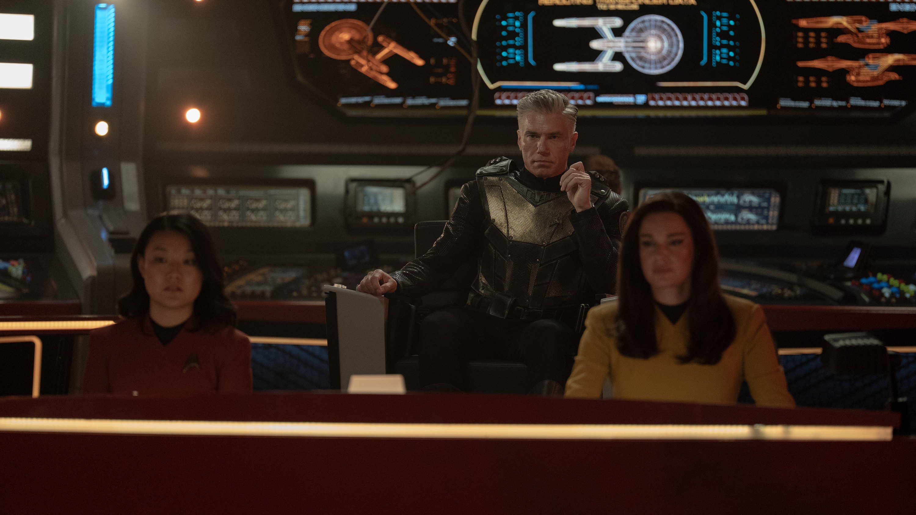 Rong Fu as Mitchell, Rebecca Romijn as Una and Anson Mount as Capt. Pike sitting on the bridge of the Enterprise in Star Trek: Strange New Worlds season 3