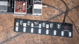 A Keith McMillen MIDI floor controller on the floor with a pedalboard