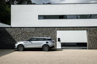 Range Rover hybrid car being charged up outside house