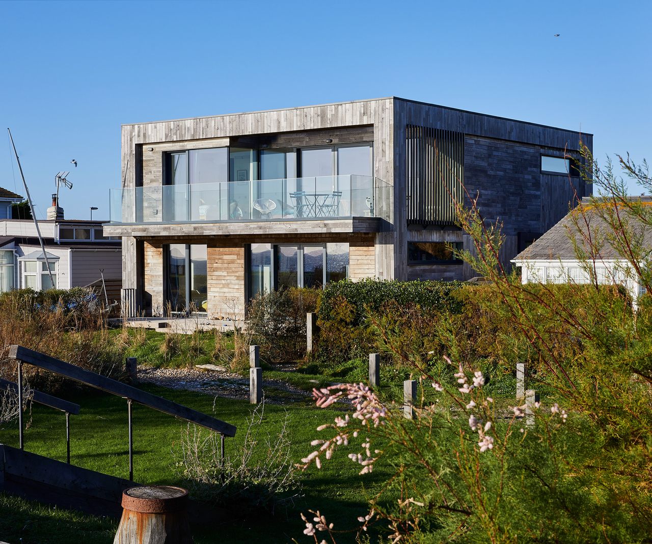 A contemporary seaside property renovation clad in timber with large triple-glazed windows