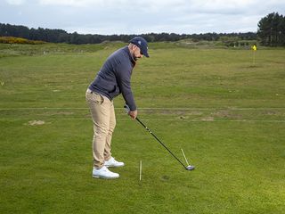 Peter Finch practicing with a 3-wood on the driving range