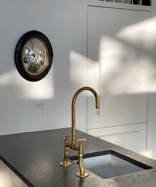 Gold tap on black marble work surface