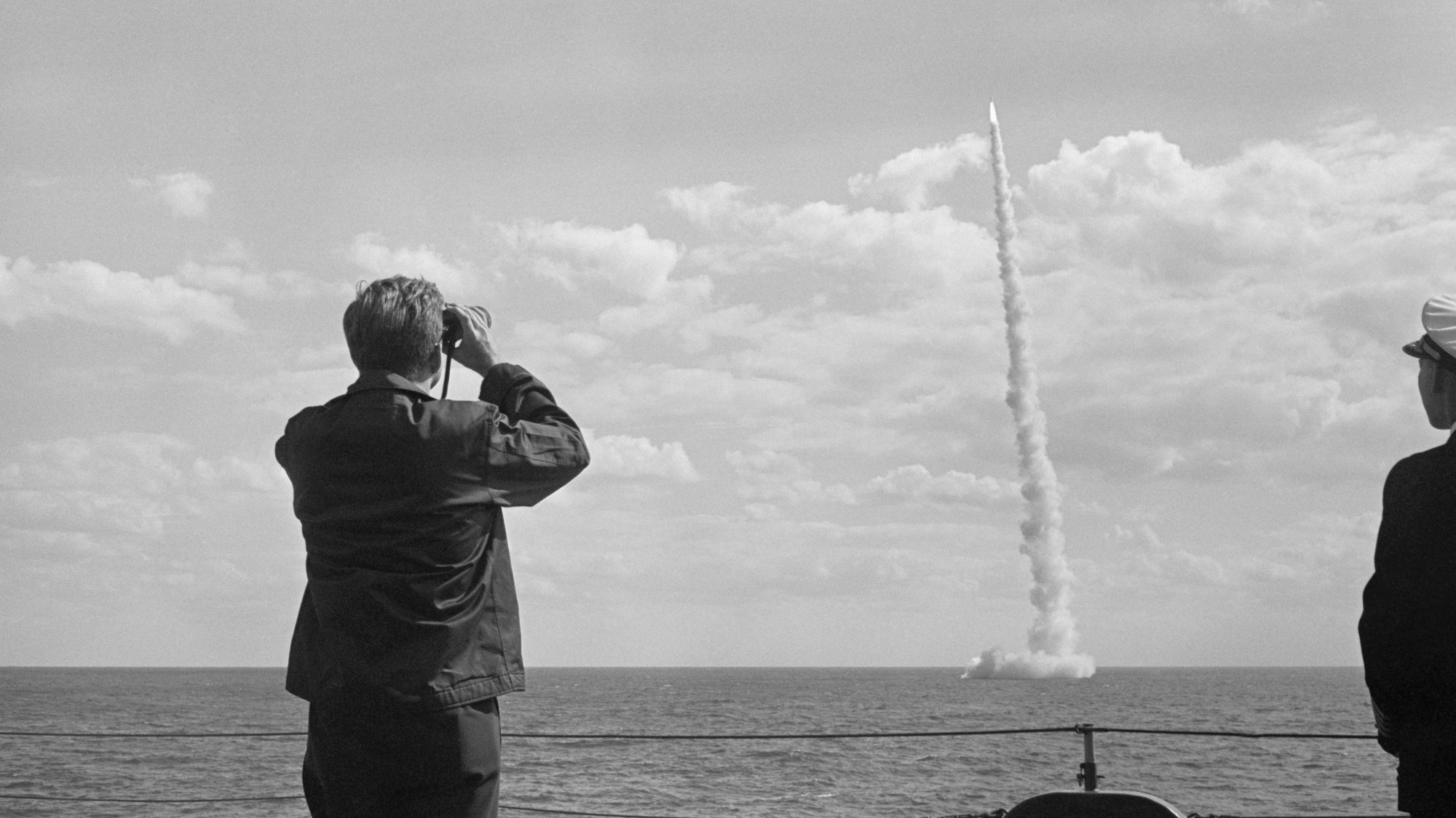 President John F. Kennedy watches the launch of a Polaris missile through binoculars
